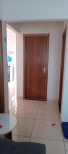 Habitación con puerta de madera y suelo de baldosa. en Quarto Rustico em Alfenas, en Alfenas