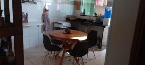 a small kitchen with a wooden table and chairs at Quarto Rustico em Alfenas in Alfenas +12 photos