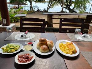 a table with plates of breakfast food on it at Sunmoon Beach Resort Likupang Timur in Pulau Mogogimbun