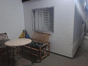 Casa na Praia في برايا جراندي: غرفة بها كرسيين وطاولة ونافذة +5 صور