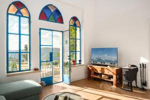 a living room with three stained glass windows at Historical 2 bedrooms home with a Private Jacuzzi in ‘En Kerem