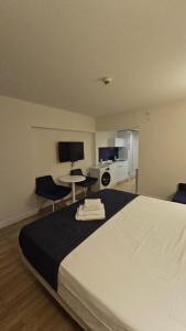 a bedroom with a large white bed and a kitchen at Premium Class Aparthotel with Sea View high floor in Batumi