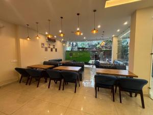 Un restaurante con mesas y sillas de madera en una sala. en Hotel Ramayan Inn, en Rishīkesh