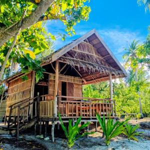 a bamboo house with a thatched roof at Naviza Homestay in Kepulauan Fam