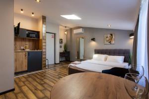 a hotel room with a bed and a table at Сучасна квартира в центрі на Харківській набережній 3-2 in Kharkiv