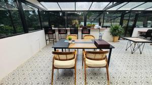 a dining table and chairs in a room with windows at Indulge House in Revora