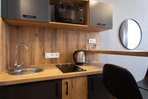 a kitchen with a sink and a microwave at Сучасна квартира в центрі на Харківській набережній 3-2 in Kharkiv +161 photos