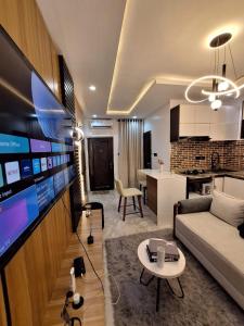 a living room with a couch and a table and a kitchen at Cozy 1 Bedroom Studio Apartment in a Gated Estate in Lagos