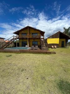 a house with a deck and a pool in the yard at Pousada Suyhê in Caraíva