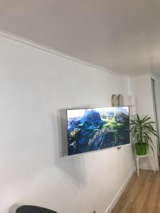 a flat screen tv hanging on a white wall at Charmant Studio indépendant in Louvres