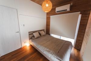 a bedroom with a bed and a chandelier at Haruhiya in Ishigaki Island +32 photos
