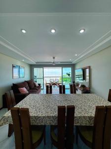 ein Esszimmer mit Tisch und Couch in der Unterkunft Apartamento lindo frente ao mar in Guarapari