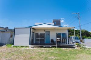a small white house with a blue door at Haruhiya in Ishigaki Island