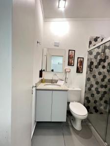 a bathroom with a toilet and a sink and a mirror at Casa e Negócios in Mairiporã
