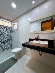 ein Badezimmer mit Waschbecken, Toilette und Dusche in der Unterkunft Apartamento lindo frente ao mar in Guarapari + 15 Fotos