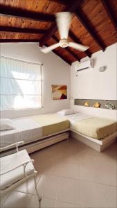 two beds in a room with a ceiling fan at Alquiler casa en la playa, Tolu in Tolú +35 photos
