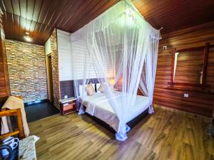 a bedroom with a bed with a mosquito net at Ella Happy View Homestay in Ella