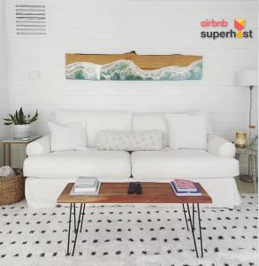 a living room with a white couch and a table at Beachside Modern Wellness Villa with Spacious Patio in Jupiter