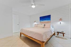 a bedroom with a bed and a painting on the wall at Beachside Modern Wellness Villa with Spacious Patio in Jupiter +37 photos