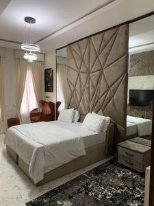 Un dormitorio con una cama grande con un cabecero grande. en Bethaven, en Lekki