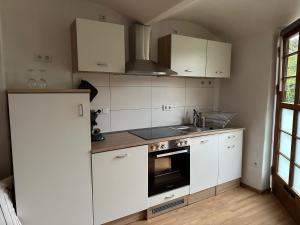 a kitchen with white cabinets and a stove top oven at Ferienwohnung Schloss Hemhofen in Hemhofen