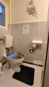 a bathroom with a toilet with a blue lid at Up'N'Down - Rooms in Nürnberg