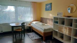 a bedroom with a bed and a table and a window at Up'N'Down - Rooms in Nürnberg