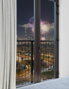 a view of a fireworks display from a hotel room window at Ultimate Stay Port de La Mer with Burj Khalifa Views from the Bed next to the Beach in Dubai