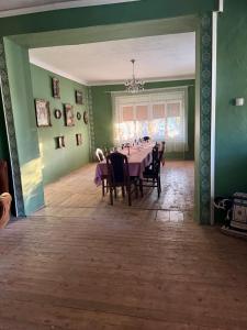d'une salle à manger avec une table, des chaises et des murs verts. dans l'établissement Vinarija Ljutica Winery Ljutica, à Lovćenac