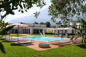ein Swimmingpool mit Liegestühlen und Sonnenschirmen in der Unterkunft Seven Park Hotel Lake Como - Adults Only in Colico