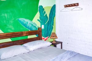 a bedroom with a bed with a painting on the wall at Quarto Privativo Casal - Banheiro Compartilhado in Pipa
