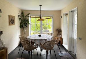 a dining room with a table and chairs and a window at Lake View Apartment at North Lakeside Villa Plateliai in Medsėdžių