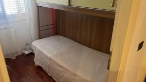 a small bedroom with a white bed in it at il campanile in Gaeta