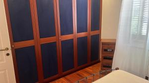 a bedroom with blue walls and a wooden closet at il campanile in Gaeta