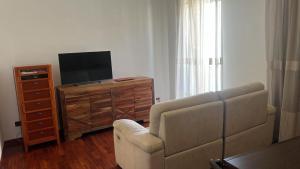 a living room with a couch and a tv and a dresser at il campanile in Gaeta