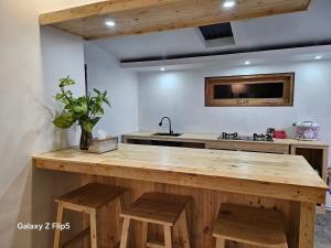 a kitchen with a wooden counter and a sink at Erigeron homestay dieng in Banjarnegara