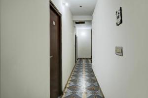 einen Flur mit Fliesenboden und einer Tür in der Unterkunft Hotel O by OYO Swagat in Bhiwadi