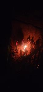 a group of people standing around a fire at night at Angel Hollidays ooty in Ooty