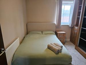 a small bedroom with a bed with a towel on it at Spacious 2-bedroom Flat, Edgware London in Edgware