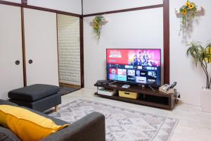 a living room with a tv and a couch at DK Matsunaga House in Fukuyama