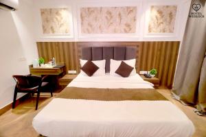 a bedroom with a large bed with a desk and windows at The Wedlock Hotel in Gurgaon