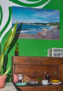 a green wall with a painting of a beach at Quarto Privativo Casal - Banheiro Compartilhado in Pipa