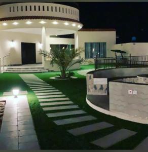 un patio de una casa por la noche en شاليه هاوس مون, en Al Rass