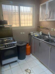 una cocina con estufa y fregadero en شاليه هاوس مون, en Al Rass 13 fotos más