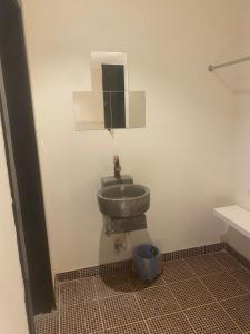 Un baño con un lavabo y un espejo en la pared. en شاليه هاوس مون, en Al Rass