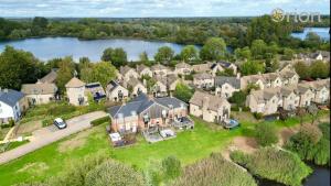an aerial view of a large house with a lake at Mill Village 81, Trout Cottage in Somerford Keynes