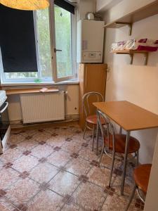 kuchnia ze stołem, krzesłami i lodówką w obiekcie Centru Vechi Craiova w Krajowej +1 zdjęcie