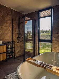 baño grande con bañera y ventana grande en The View Marisel, en Mărişel