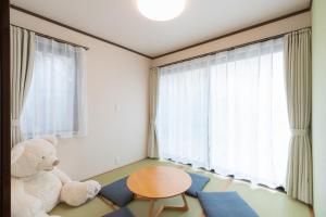 Un oso de peluche sentado en una habitación con una mesa. en 松島雅居, en Tokio