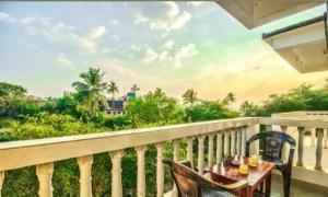 a balcony with a table and chairs and a view at Pasquina guest house in Calangute